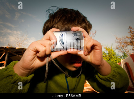 Nahaufnahme eines kleinen Jungen mit dem Fotografieren mit digitalen Kompaktkameras Stockfoto