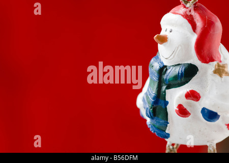 Nahaufnahme einer handgefertigten Schneemann Weihnachten Dekoration auf rotem Grund Stockfoto
