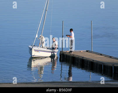 Setzen in ein kleines Segelboot an der Bootsrampe Reservoir. Stockfoto