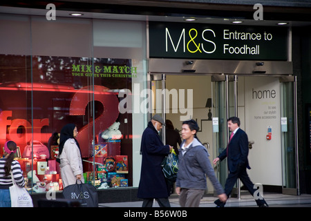 Käufer zu Fuß vorbei an Marks & Spencer Eingang zu Food Hall in Oxford Street; London, W1 Stockfoto