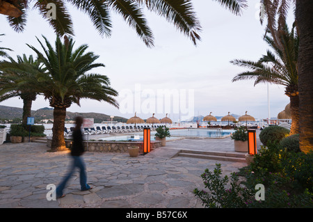 Eine Person zu Fuß durch Palmen Hafen von Pollensa, Mallorca, Spanien. Stockfoto