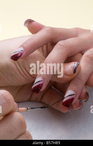 Die Dekoration der falsche Nägel mit einem Pinsel. Dekoration de faux Ongles au Pinceau. Stockfoto