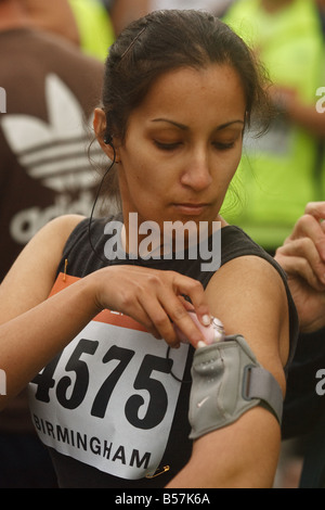 Attraktive asiatische Sportlerin bereitet ihre Musik vor dem Rennen Stockfoto