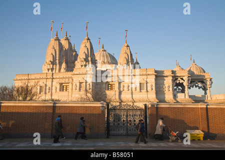 Menschen zu Fuß vorbei an Shri Swaminarayan Mandir-Tempel, Gewinner des UK Ehrenplatz award 2007, Neasden, London, England Stockfoto