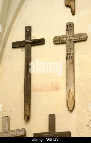 hölzerne Kreuze aus alten Gräbern der ersten Weltkrieg an der Wand innen St Marys Pfarrkirche in Cavendish, Suffolk, UK Stockfoto