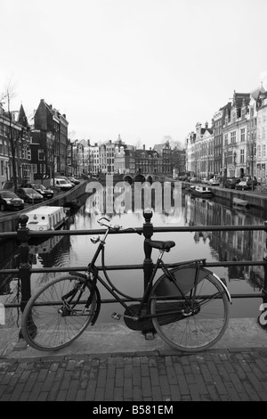 Schwarz / weiß-Bild von einem alten Fahrrad durch die Singel Kanal, Amsterdam, Niederlande, Europa Stockfoto