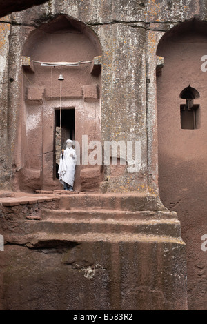 Ein Priester steht am Eingang zu den Fels gehauene Kirche von Bet Gabriel-Rufael, in Lalibela, UNESCO-Weltkulturerbe, Äthiopien Stockfoto