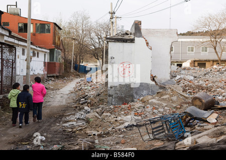 Mädchen zu Fuß in einer Nachbarschaft Hutong teilweise zerstört und markiert für Abriss, Peking, China, Asien Stockfoto