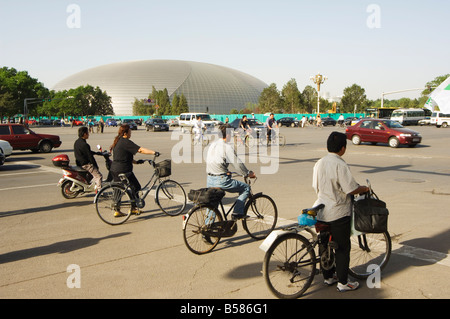 Das Nationaltheater, entworfen von dem französischen Architekten Paul Andreu und Radfahrer pendeln im Zentrum von Peking, Beijing, China Stockfoto