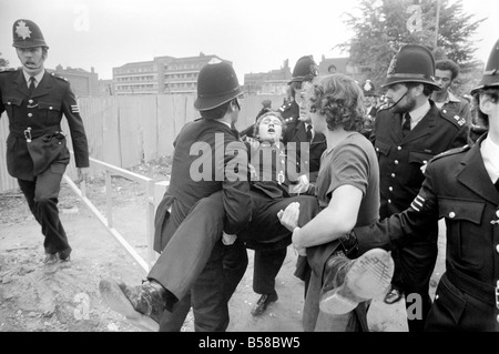 Lewisham Riot 1977: Ein verletzter Polizist wird von Kollegen von das Lewisham Riot getragen. Der Aufstand wurde ausgelöst von einer nationalen Front Marsch durch das Zentrum der Stadt, die durch eine linke Zähler Demonstration konfrontiert wurde. August 1977 77-04357-017 Stockfoto