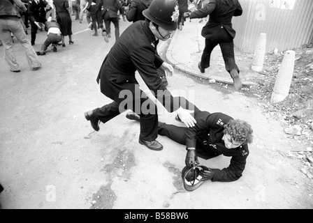 Lewisham Riot 1977: Ein verletzter Polizist wird Weg von das Lewisham Riot von Kollegen geführt. Der Aufstand wurde ausgelöst von einer nationalen Front Marsch durch das Zentrum der Stadt, die durch eine linke Zähler Demonstration konfrontiert wurde. August 1977 77-04357-018 Stockfoto