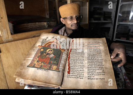 Ein Priester geht über einer alten Handschrift im Kloster von Kebran Gabriel, auf einer Insel im See Tana, Äthiopien, Afrika Stockfoto