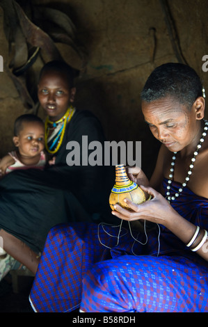 Eine Frau des Stammes Datooga dekorieren einer Kalebasse mit Glas Perlen Norden zentralen Tansania südlich von Ngorongoro Stockfoto