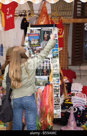 Junge Frau betrachten Postkarten auf einem Souvenir-Stand Stockfoto