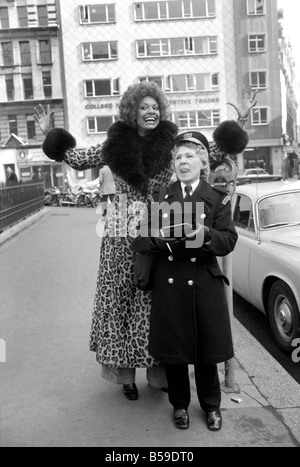 Modell Lorne Lesley trägt einen langen Leopard Hautmantel mit Pelzkragen hinter einem Traffic Warden; Februar 1975; 75-01140 Stockfoto