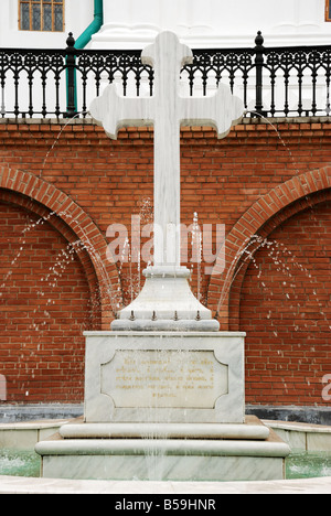 Steinkreuz Kreuz ein Brunnen in einem Mann s Kloster von Öffnungen fließt das heilige Wasser Stockfoto