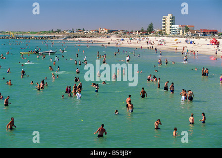 Gruppen von Menschen im Meer und am Strand von Glenelg, wo erste South Australian Kolonisten landeten, Australien Stockfoto