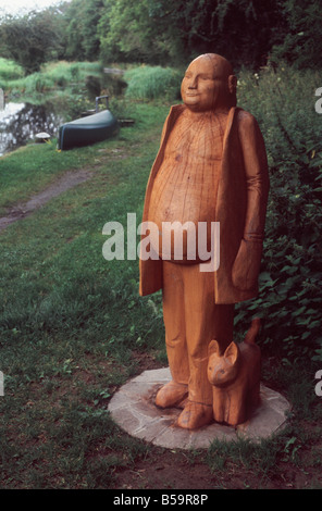 Holzstatue der ein dicker Mann und sein Hund stehend neben dem Leinpfad des Montgomery-Kanals, in der Nähe von Welshpool, Powys, Wales Stockfoto