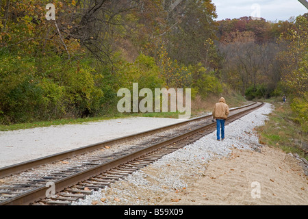 Mann geht entlang Eisenbahnschienen Stockfoto