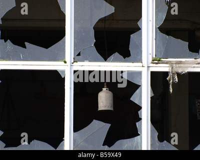 Zerbrochene Fensterscheiben an einer alten verlassenen Fabrik Stockfoto