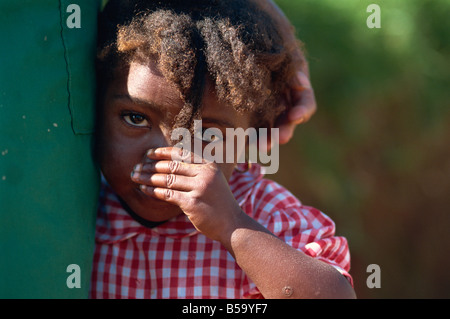 Kleines Kind in rot Check Shirt an Mutters Seite, Godet, Haiti, Karibik, Mittelamerika Stockfoto