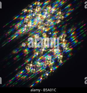 Funkelnde Diamanten auf schwarzem Hintergrund mit Farblicht Stockfoto