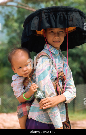 Frau in traditioneller Kleidung und großen schwarzen altertümlichste Hut mit ihrem Baby in Hong Kong China Asien Stockfoto
