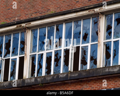 Zerbrochene Fensterscheiben auf eine alte Ziegel Mauern umgebene Gebäude Stockfoto