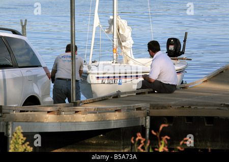 Setzen in ein kleines Segelboot an der Bootsrampe Reservoir. Stockfoto