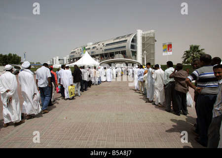 Arabische Männer warten in Schlangen vor der Nad Al Sheba Pferd Rennstrecke, Dubai, Vereinigte Arabische Emirate Stockfoto