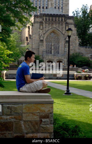 Asiatische Studentin Weiterlesen Yale Campus mit Sterling-Bibliothek im Hintergrund. Stockfoto