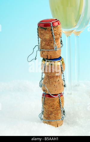 Drei Flasche Champagner-Korken und zwei gefüllte Gläser Stockfoto