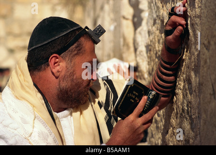 Nahaufnahme der Jude trägt Schal, Käppchen und Phylakterion und hält ein Buch, betet an der Klagemauer in Jerusalem, Israel Stockfoto