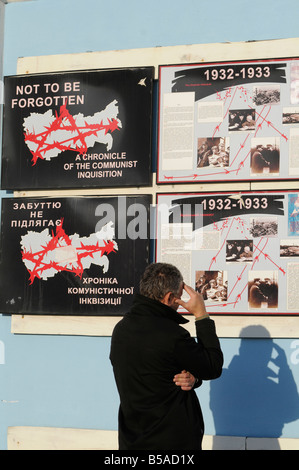 Ein Mann betrachtet ein Poster mit einer Beschreibung der Geschichte der großen Hungersnot (Holodomor) an einem Denkmal in der Nähe von Kloster St. Michael in Kiew Stockfoto