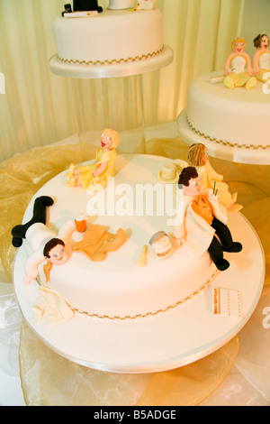 Humorvolle Hochzeitstorten mit Marzipanfiguren für Braut, Bräutigam und Gäste. Stockfoto