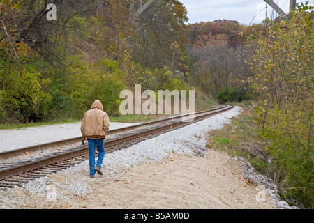 Mann geht entlang Eisenbahnschienen Stockfoto