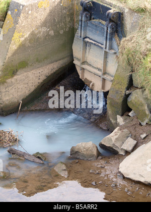 Trübe verschmutztes Wasser kommt heraus aus einen Abfluss in den Fluss ordentlich, Bude, Cornwall Stockfoto