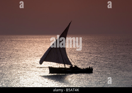 Einer traditionellen hölzernen Dhau Segeln in der Nähe von Stone Town bei Sonnenuntergang Sansibar Tansania Ostafrika Africa Stockfoto