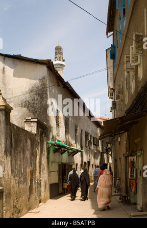 Eine belebte Straße mit einem Minarett der Moschee oben in Stone Town Sansibar Tansania Ostafrika Africa Stockfoto