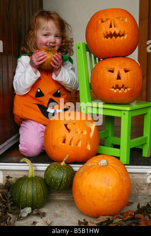 Ein Kind an Halloween verkleidet als Hexe mit ihren Kürbissen Stockfoto