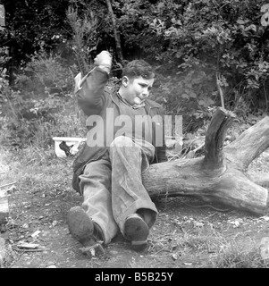 Behinderung und Jugend: Tommy Hoare die beinlosen Boy scout gesehen, hier genießen Sie camping, gesehen hier hacken Holz für das Lagerfeuer. Juli 1955 Stockfoto