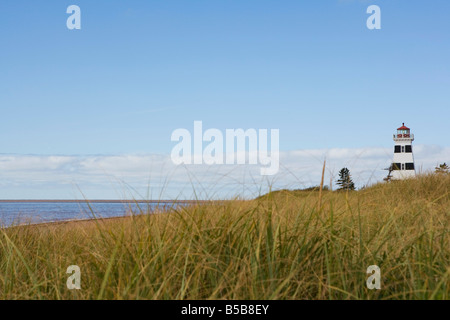 Rasen wächst entlang der Dünen vor dem West Point Leuchtturm am Strand auf Prince Edward Island, Kanada. Stockfoto