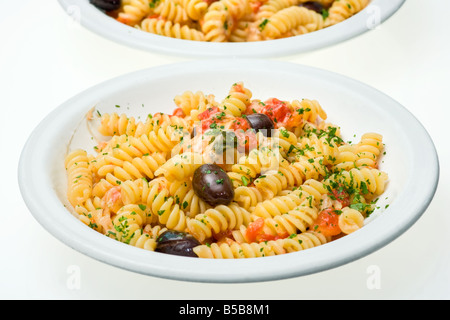 Zwei Teller von Fusilli mit Käse, frischen Tomaten und Oliven isoliert auf weiß Stockfoto