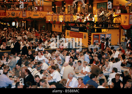 Jährliche Oktoberfest Bier großen Festspielhaus leuchtet auf Decke Personen an Tischen trinken aus Bierkrügen Liter Krüge München Stockfoto