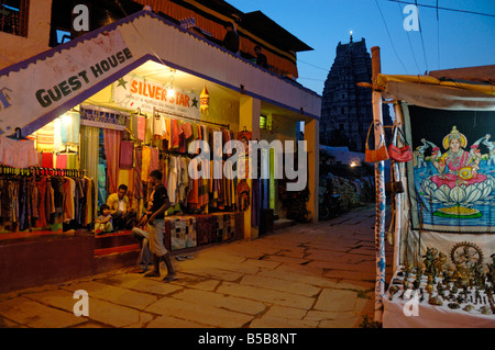Shopping-District in Hampi Bazar nach Sonnenuntergang, im Hintergrund der Virupaksha-Tempel. Hampi, Karnataka, Indien. Stockfoto