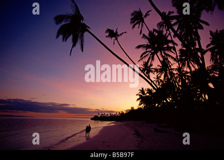 Paar und Palmen Bäume am Alona Beach Silhouette bei Sonnenuntergang auf der Insel Panglao, vor der Küste von Bohol, Philippinen Stockfoto