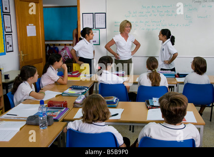 Lehrer und Junior Schüler im Klassenzimmer Proben und Rollenspiele für eine Schulaufführung Stockfoto
