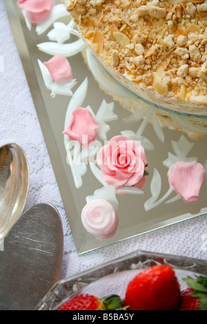 Detail eines Desserttisches mit dekorierten Kuchen, rosa Glasrosen und frischen Erdbeeren. Stockfoto