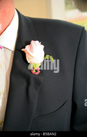 Der Bräutigam trägt ein weißes Knopfloch am Revers seines Anzugs auf einer Hochzeit. Stockfoto