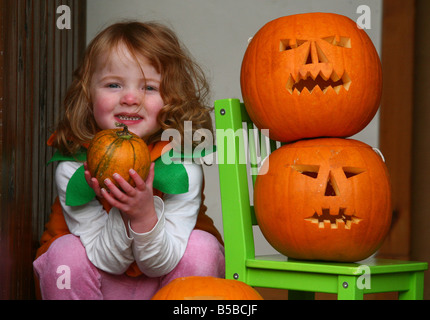 Ein Kind an Halloween verkleidet als Hexe mit ihren Kürbissen Stockfoto